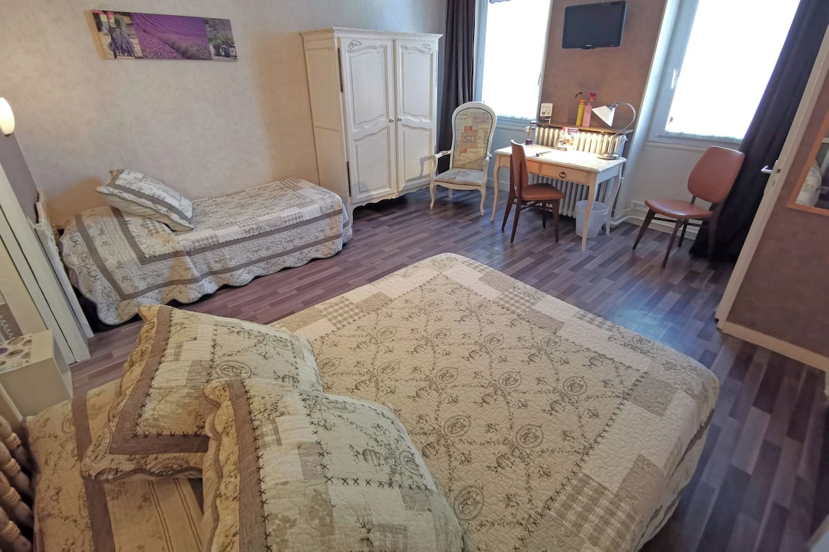 A room with a bed, a desk, a chair, and a radiator.