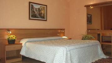 Une chambre à coucher comprenant un lit, une table de chevet, une commode et un tableau accroché au mur.