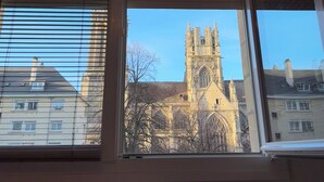 A room with a view of a cathedral through a window. - Hôtel de Caen (Caen)