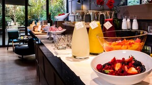 A breakfast buffet with various fruits, juices, and pastries. - Alma Barcelona GL (Barcelona)