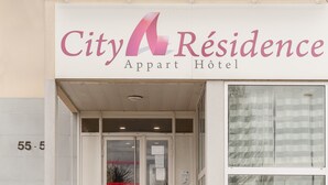 The exterior of City Residence Apartment Hotel, featuring a prominent sign with the hotel's name, a glass entrance, and a visible door number. - City Residence Chelles (Chelles)
