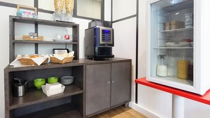 A kitchenette with a coffee machine, a refrigerator, and a shelf with kitchenware. - City Residence Chelles (Chelles)