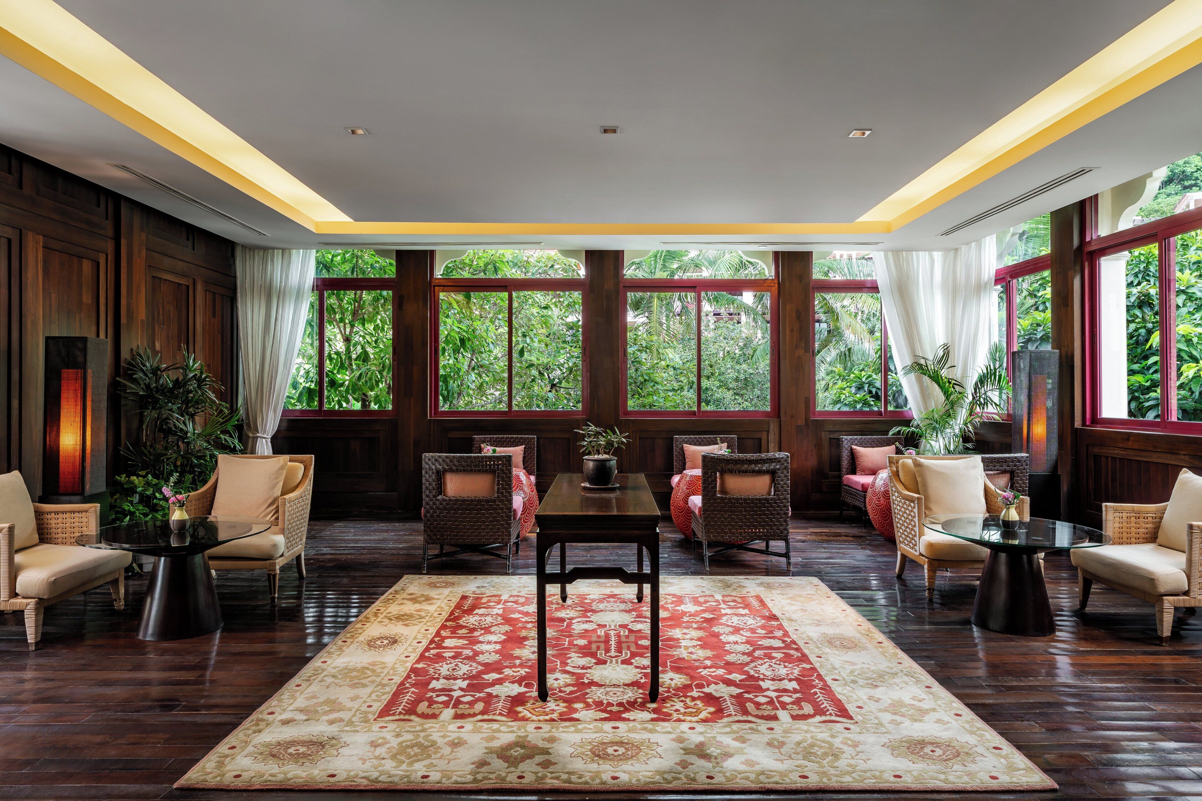 Habitación amplia con un gran ventanal, una mesa central y diversas disposiciones de asientos.