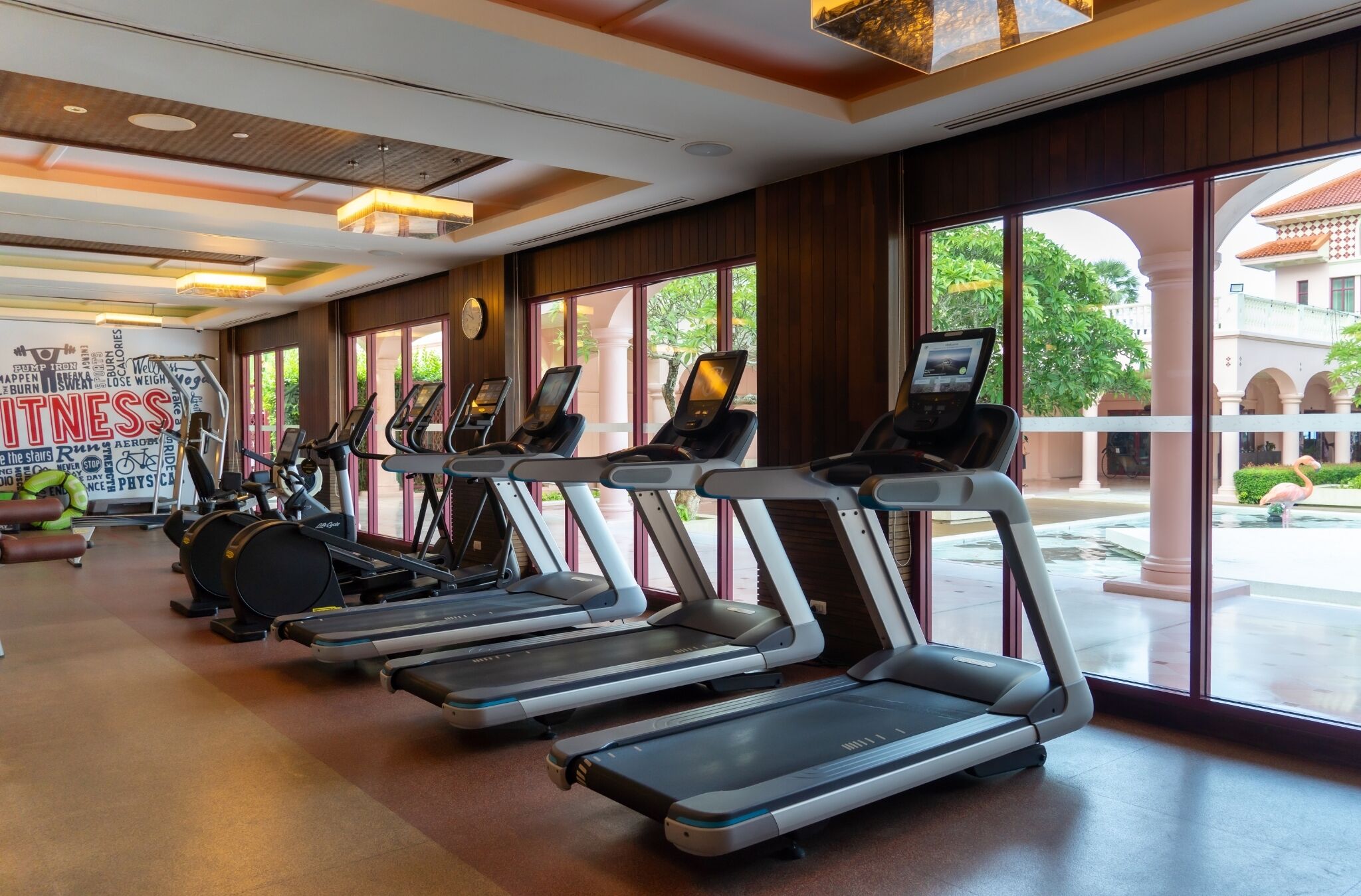 A gym with treadmills, stationary bikes, and a motivational wall.