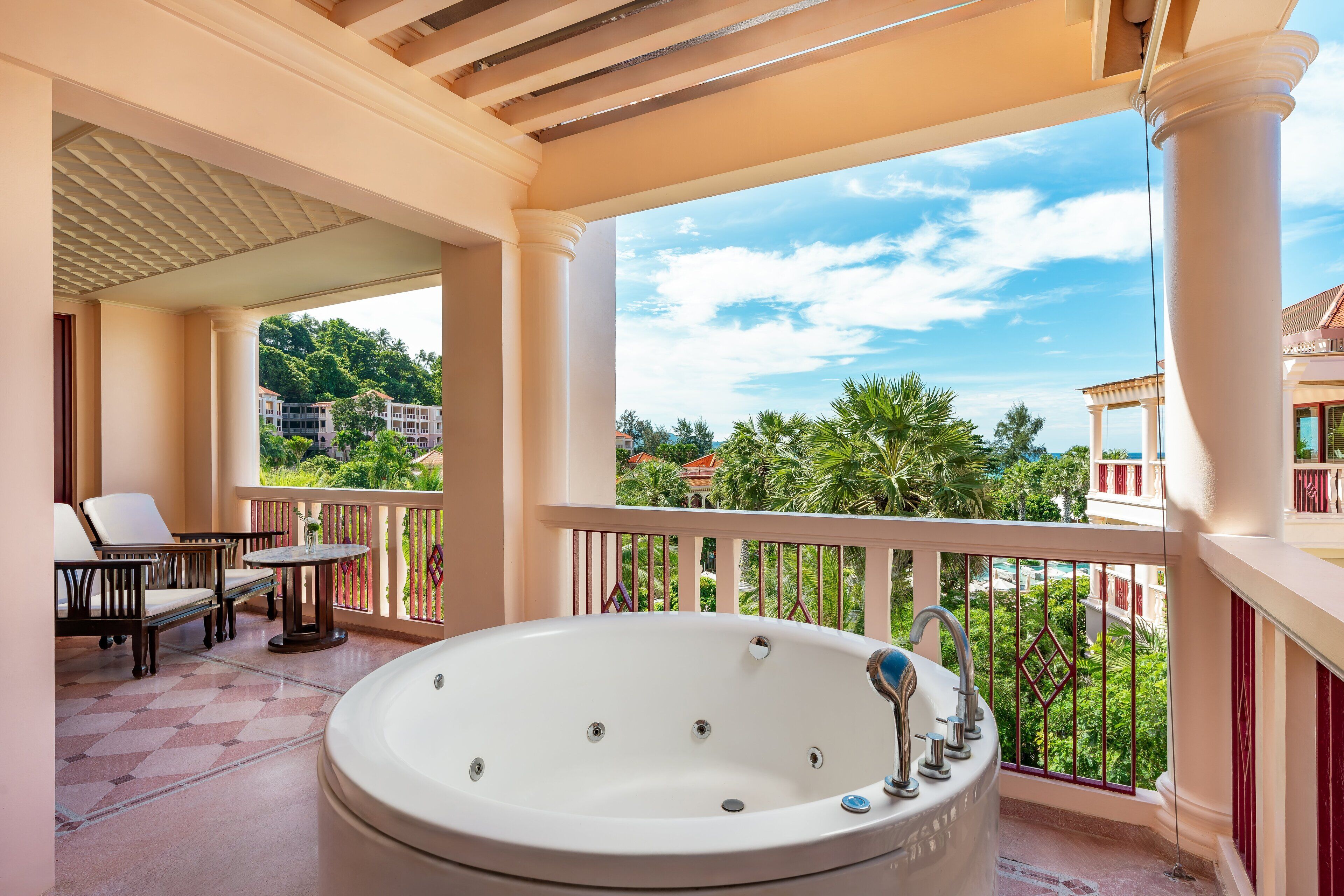 Ein Balkon mit Whirlpool, Stühlen und einem Tisch.