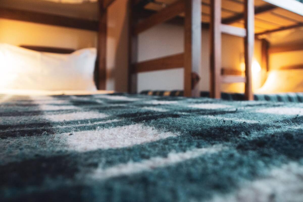 Ein Stockbett mit einer gestreiften Decke und Kissen.