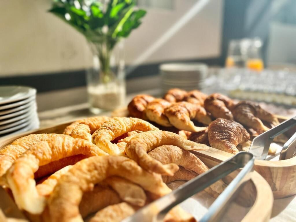 A breakfast buffet with croissants and other pastries.