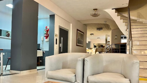 A modern living room with two light grey sofas, a glass coffee table, and a wicker basket. - Hotel Alpino (Buenos Aires)