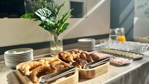 A breakfast buffet with croissants, pastries, and a variety of cheeses. - Hotel Alpino (Buenos Aires)