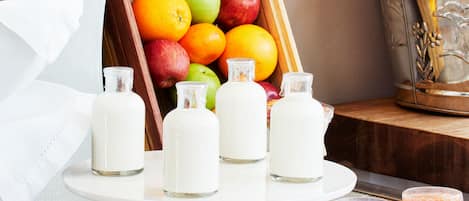 A breakfast setting with a fruit display, milk bottles, and a plate of fruit.