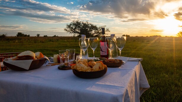 An outdoor dining setup with a table set for a meal, surrounded by a scenic landscape.