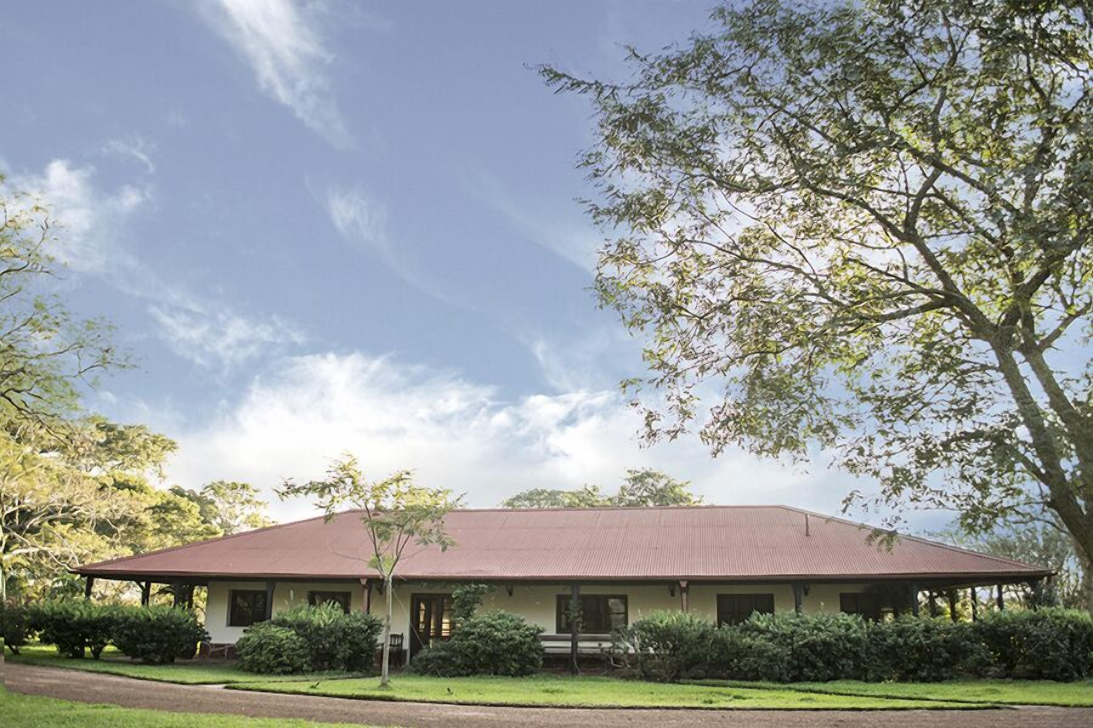 A single-story building with a flat roof, surrounded by well-maintained lawns and trees.