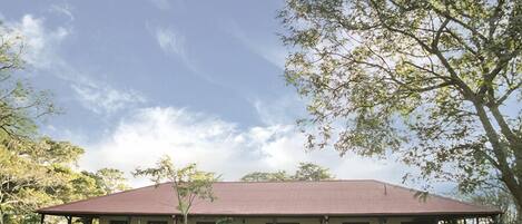 A single-story building with a flat roof, surrounded by well-maintained lawns and trees.
