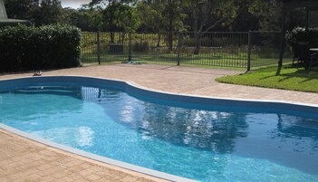 Una piscina al aire libre, sombrillas, tumbonas
