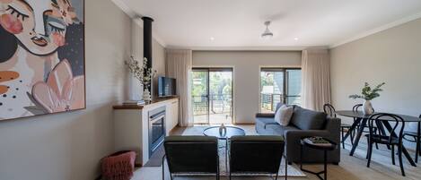 Una sala de estar moderna con chimenea, un sofá, una mesa de comedor y un televisor.
