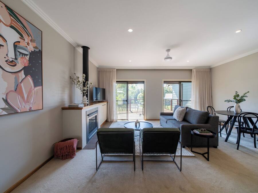 Una sala de estar moderna con chimenea, un sofá, una mesa de comedor y un televisor.