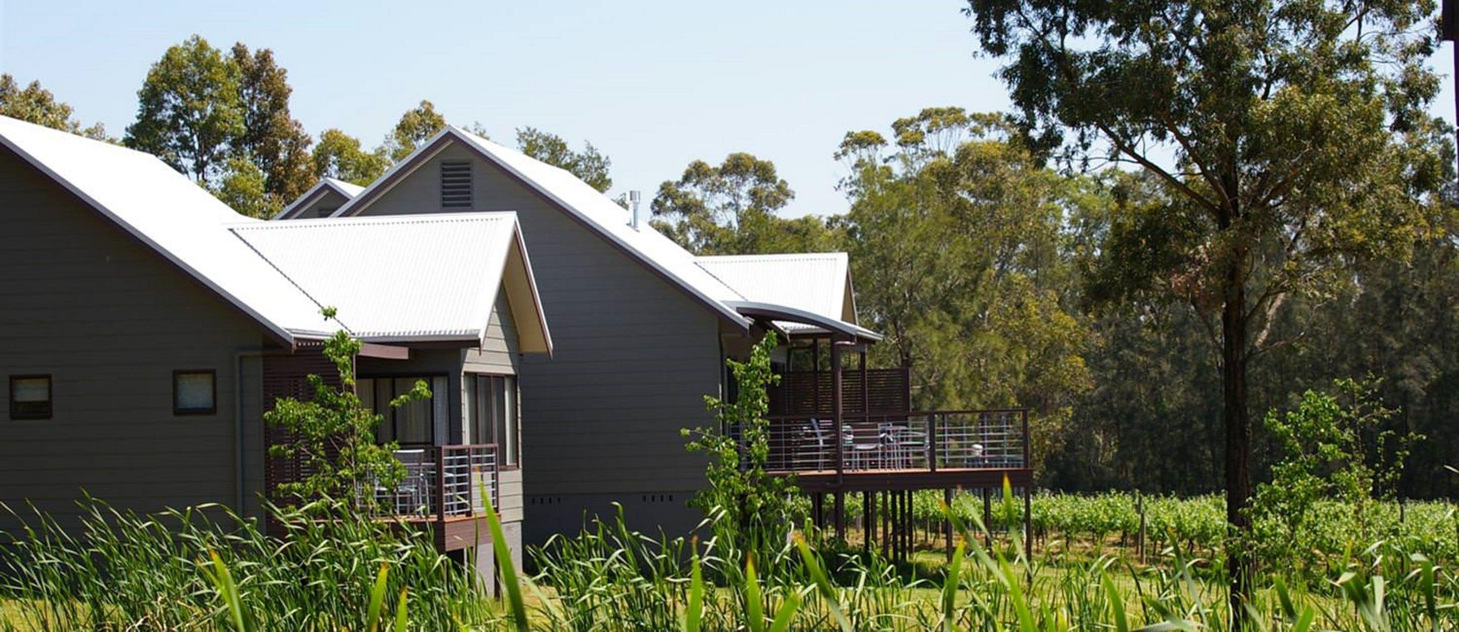 A modern building with a flat roof and a balcony with metal railings.