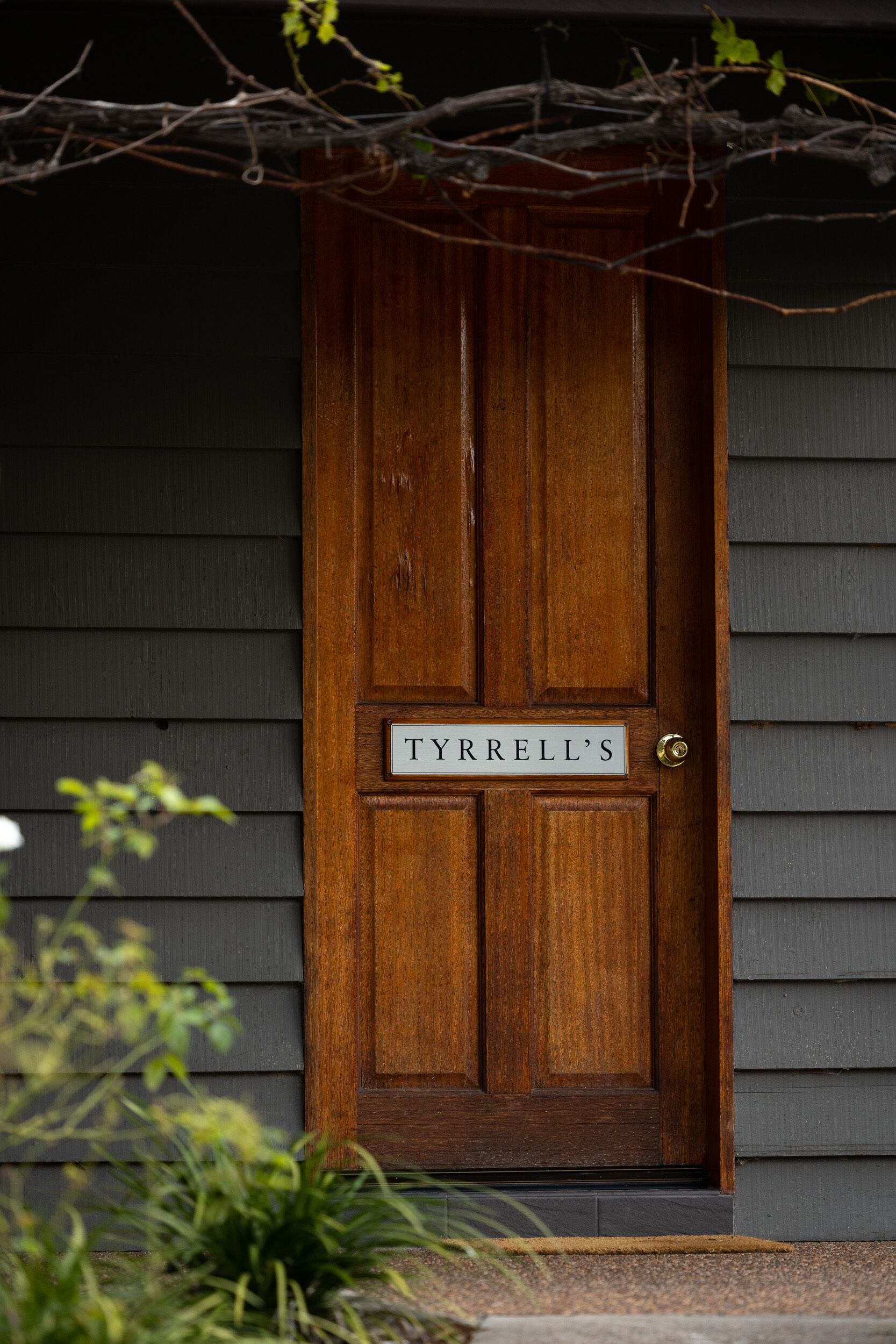 A wooden front door with a sign that reads "TYRRELL'S".