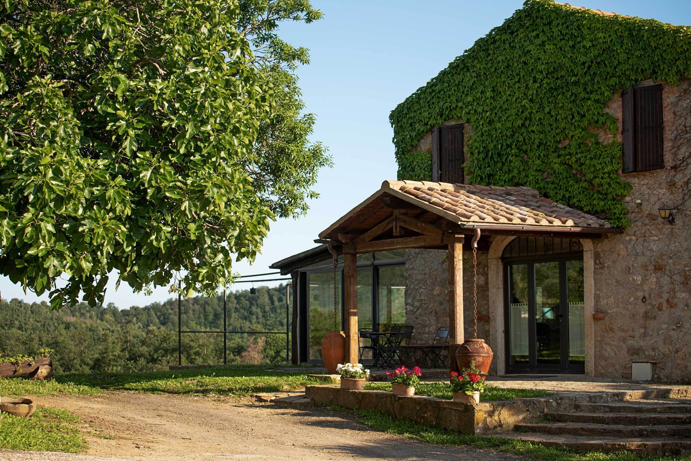 Un edificio in pietra con patio coperto, posti a sedere all'aperto e vista sul paesaggio circostante.