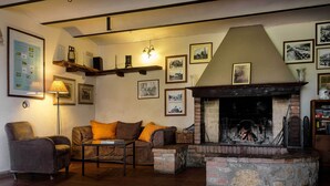 A cozy living room with a fireplace, a sofa, a coffee table, and a lamp. - Az Agrituristica Bio Le Macchie Alte (Manciano)