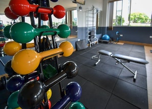 A gym with various exercise equipment, including dumbbells and a bench. - Hotel Baviera Iguassu (Foz do Iguaçu)