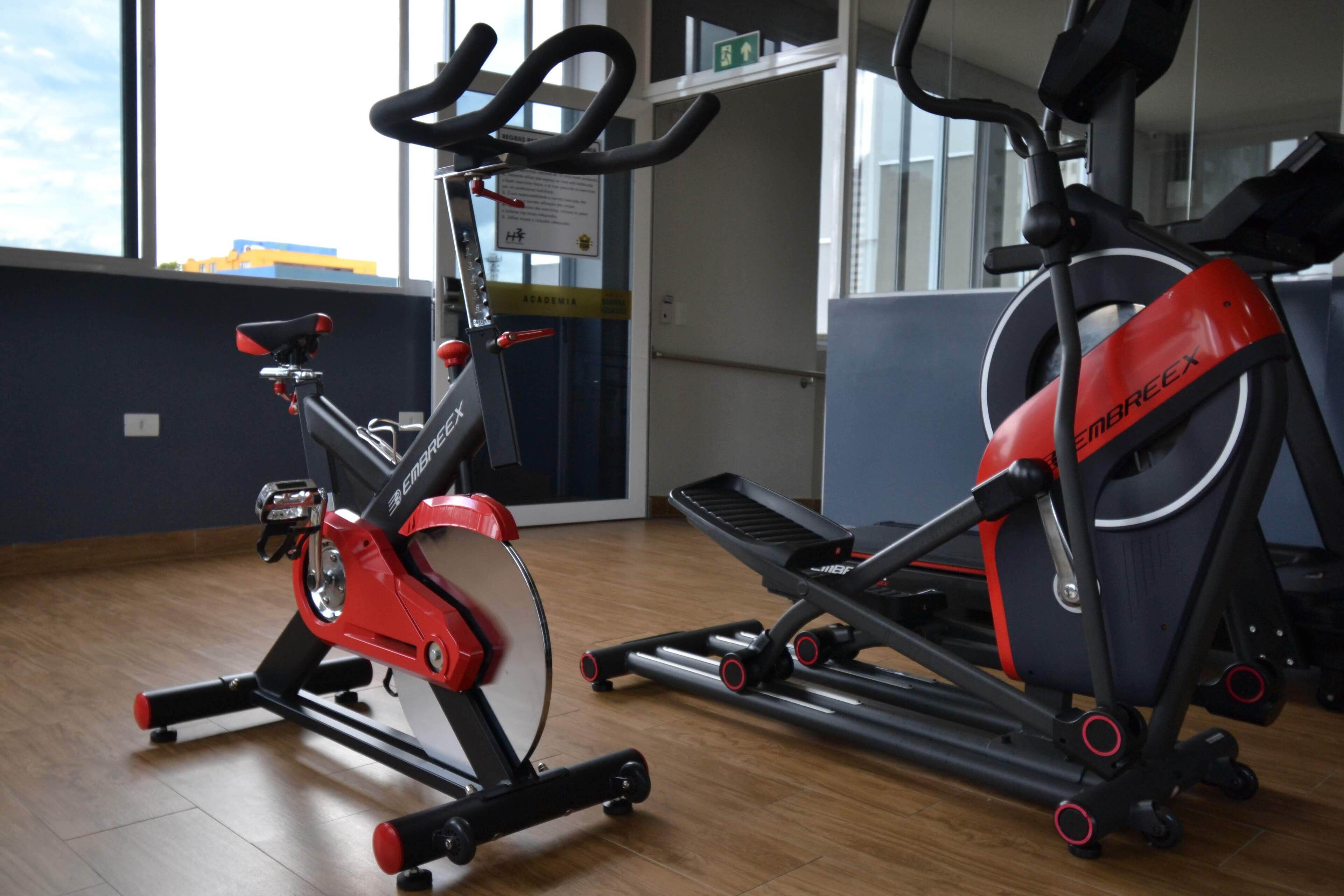 A gym with exercise equipment including a stationary bike and a treadmill.