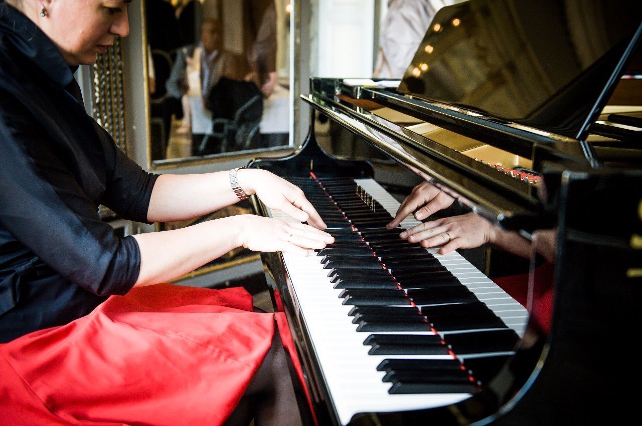 A person playing a grand piano.