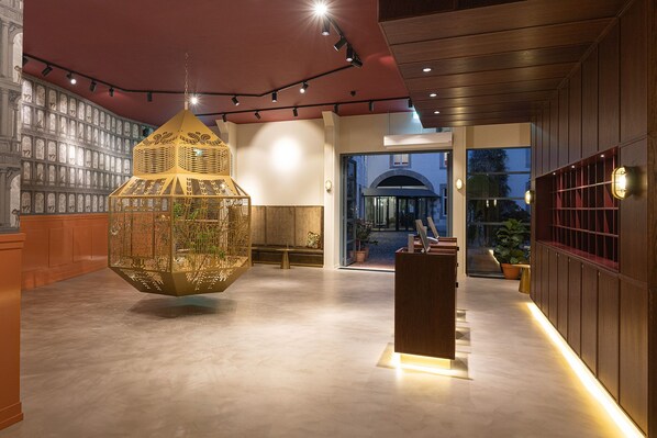 Un interior moderno con una pieza decorativa colgante, una zona de recepción y vistas al exterior.