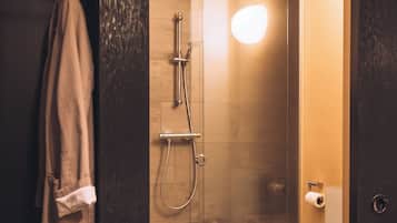 A modern bathroom with a glass-enclosed shower, a white toilet, and a towel rack.