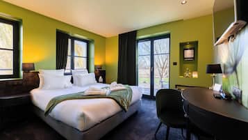 Une chambre d’hôtel avec un grand lit, un bureau et une chaise. Elle est équipée de deux fenêtres avec des rideaux, d’un climatiseur fixé au mur et d’un certificat encadré accroché au mur.