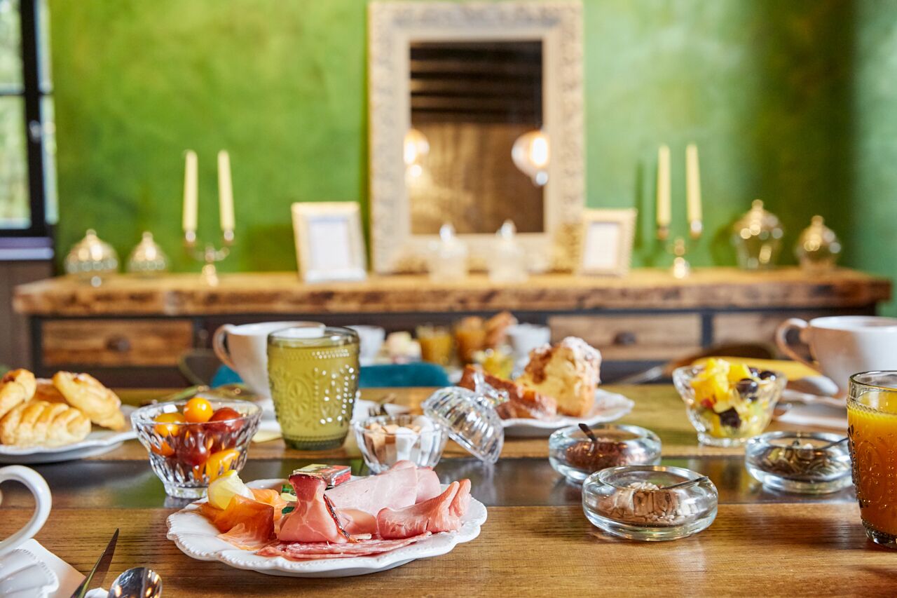 A breakfast buffet with various food items and drinks on a wooden table.