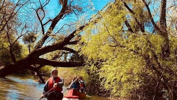 A river scene with a canoe carrying two people.