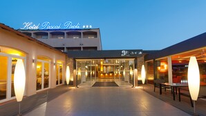 The entrance of Hotel Pascal Paoli with a glass facade, a reception area, and outdoor seating. - Pascal Paoli (Aregno)