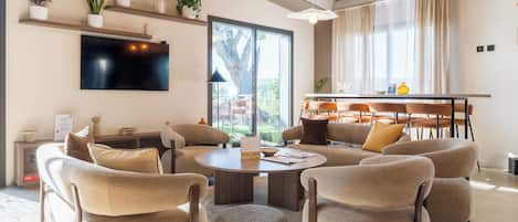Una sala de estar moderna con una mesa redonda, sofás y sillones dispuestos alrededor.