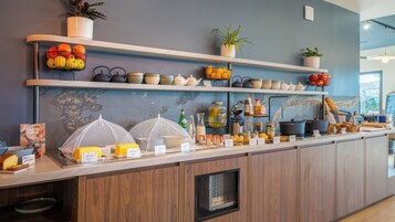 Mostrador de café con diversas opciones de comida, como pan, pastelería y salsas.