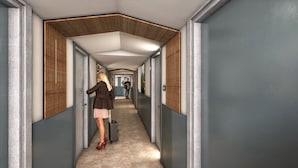 A corridor with a modern design, featuring a wooden panel wall and a geometric ceiling. - Kyriad - L'Isle-D'Abeau Bourgoin-Jallieu (L'Isle-d'Abeau)