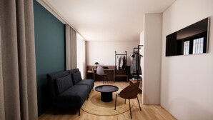 A modern living room with a sofa, a round coffee table, and a dining area with a chair and table. - Kyriad - L'Isle-D'Abeau Bourgoin-Jallieu (L'Isle-d'Abeau)