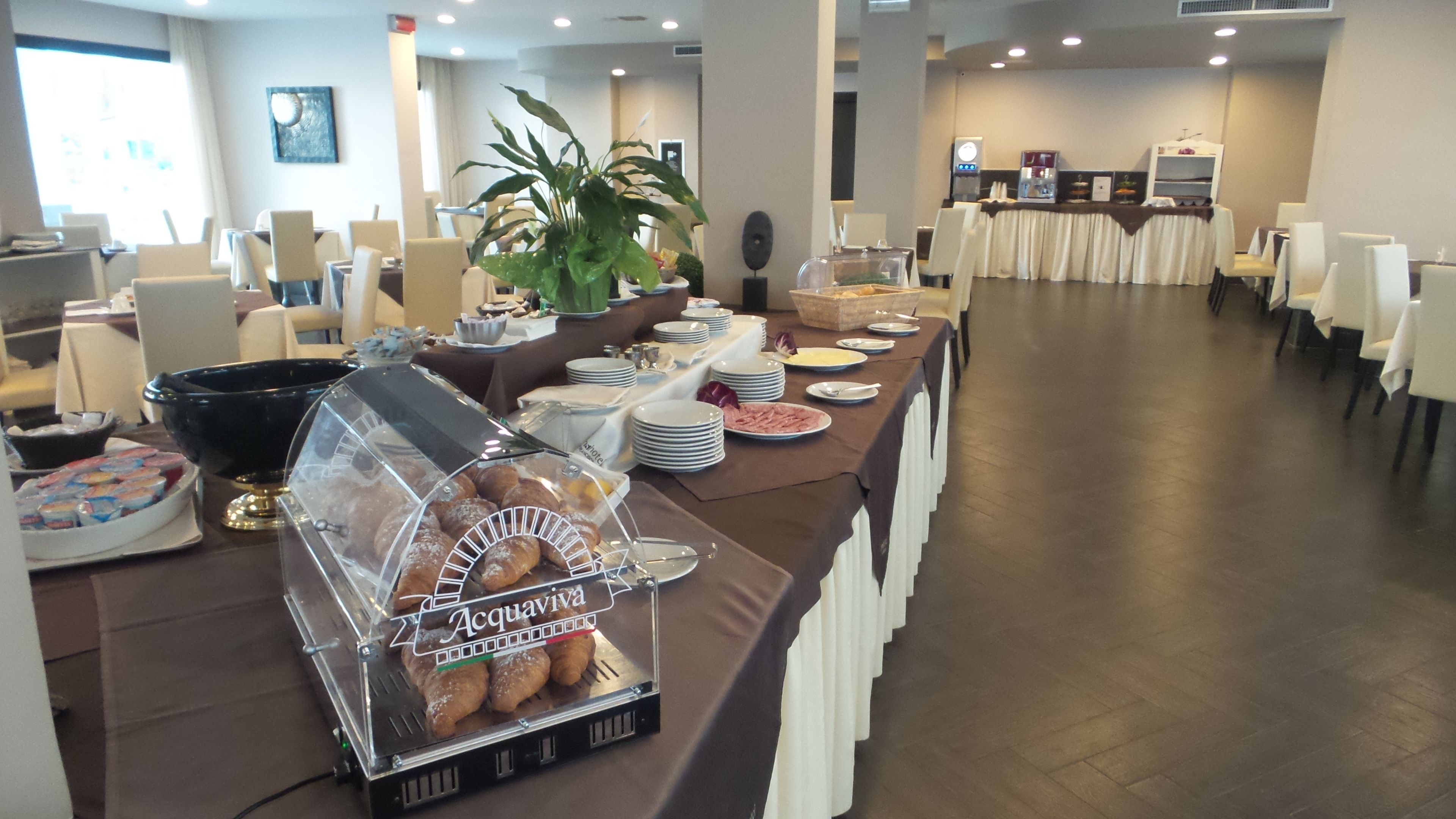 Un buffet proposant divers plats et un coin café, installé dans la salle à manger d’un hôtel.