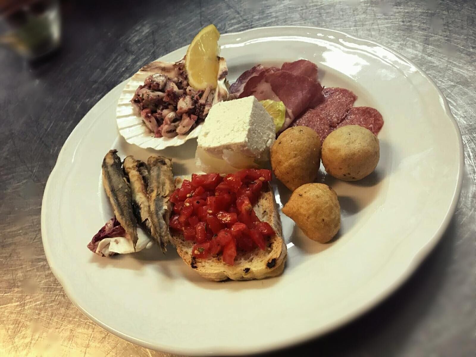A plate with various food items including octopus, bread, and fish.