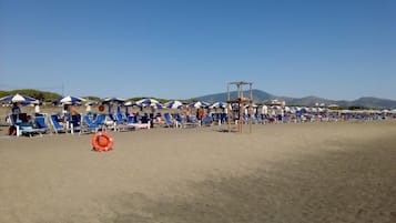 Vlak bij het strand, ligstoelen aan het strand, parasols