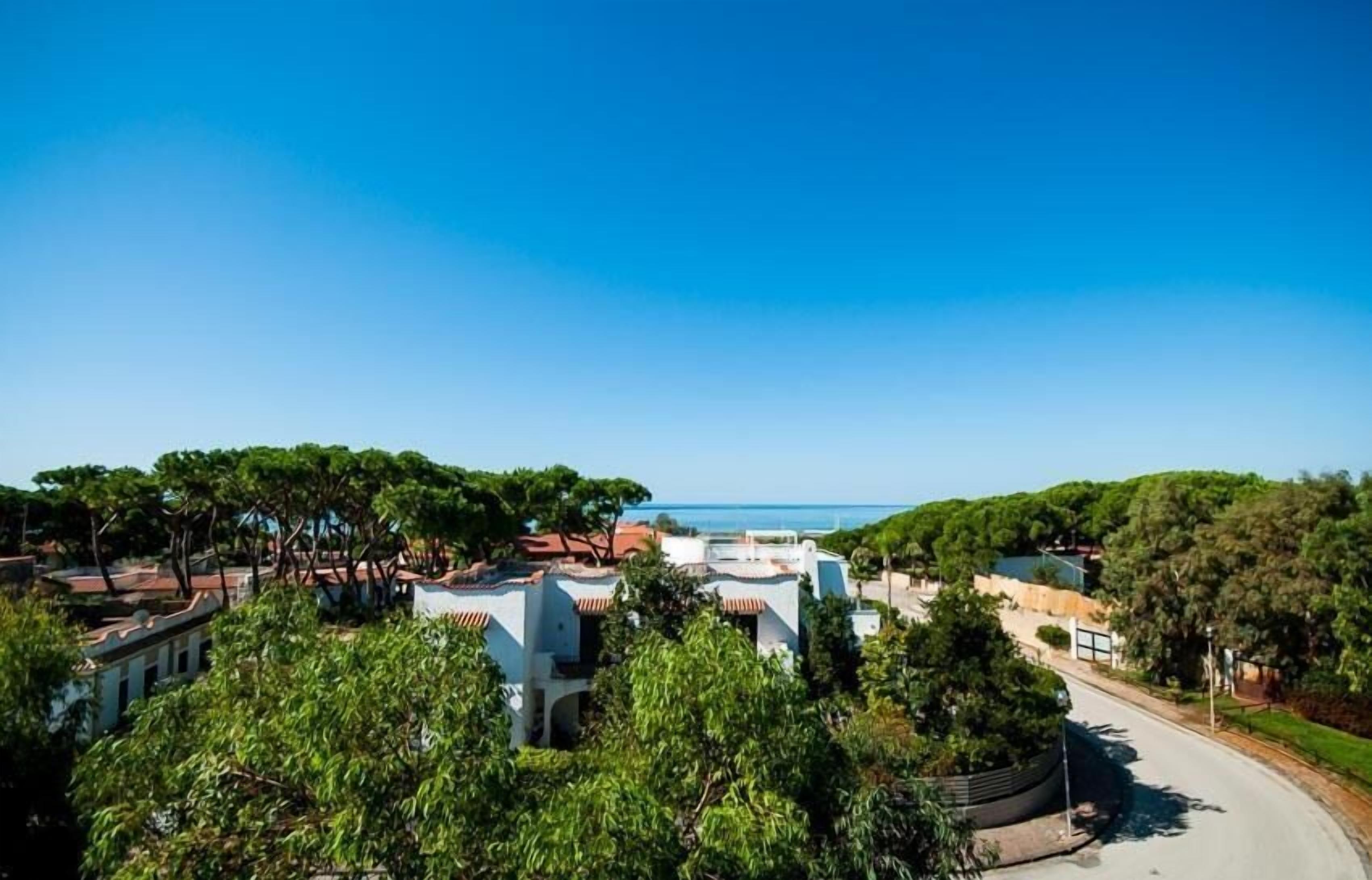 Ein Küstenresort mit Villen, üppiger Vegetation und freiem Blick auf das Meer.