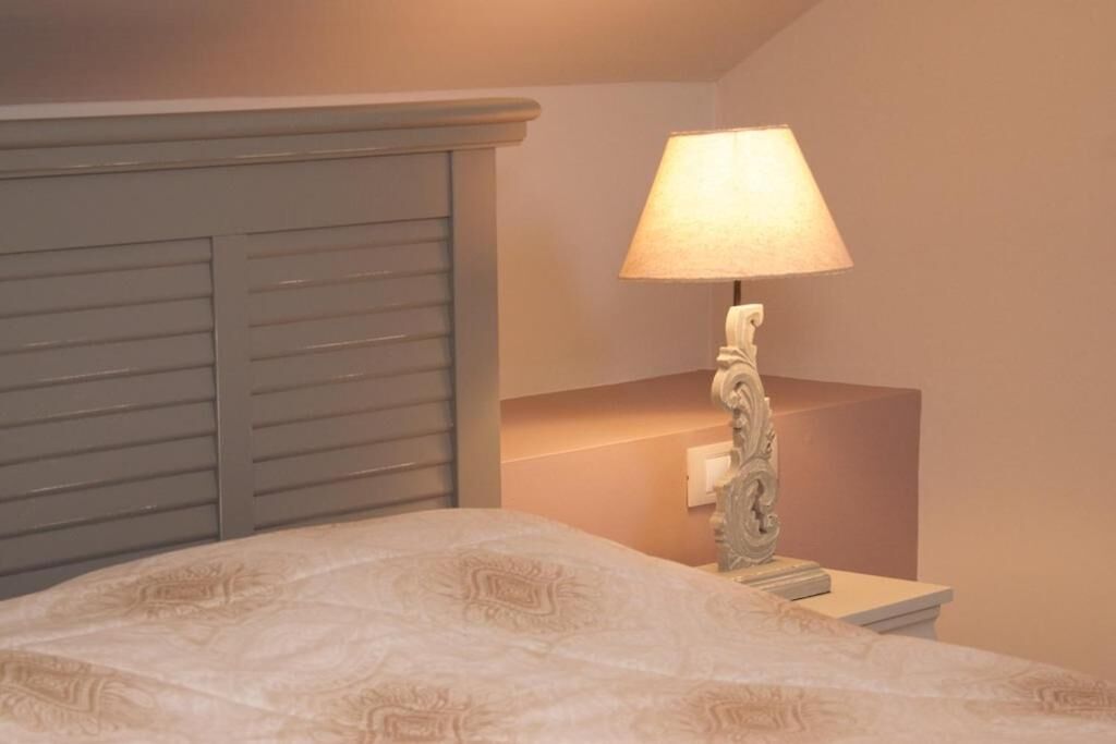 Ein Schlafzimmer mit einem Bett, einem Nachttisch und einer Lampe.