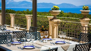 A table set for dining with a view of the sea and mountains. - Almyra Hotel (Kefalonia)