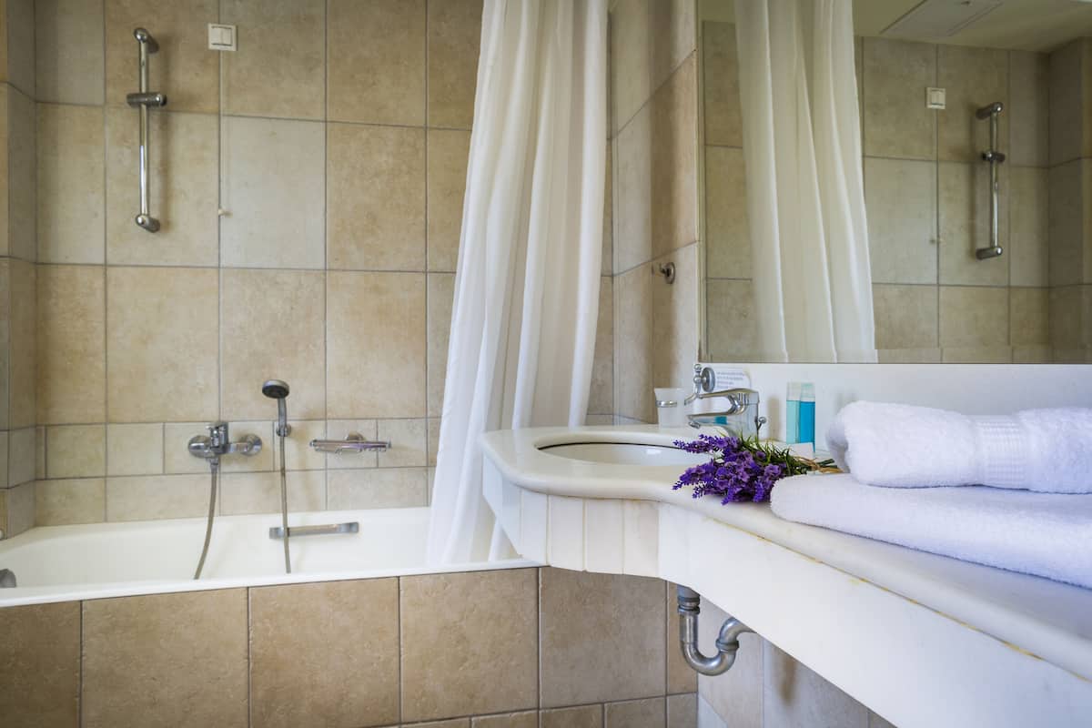 deluxe quadruple room | bathroom | combined shower/bathtub, deep-soaking bathtub, designer toiletries