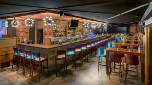 A bar area with a long counter, multiple seating options, and a television screen. - Citymax Bur Dubai (Dubai)