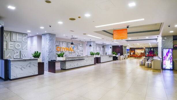 A spacious lobby with marble reception desks, a seating area, and a digital display. - Citymax Bur Dubai (Dubai)