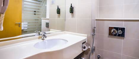 Ein modernes Badezimmer mit einem großen Waschbecken, einem Spiegel und einer Duschkabine.