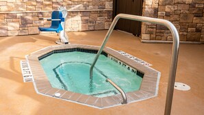Un jacuzzi con una escalera de metal y un cartel de prohibido bucear.
