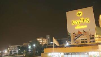 Un bâtiment surmonté d’une grande enseigne lumineuse portant l’inscription « SAFIR » et d’un drapeau.