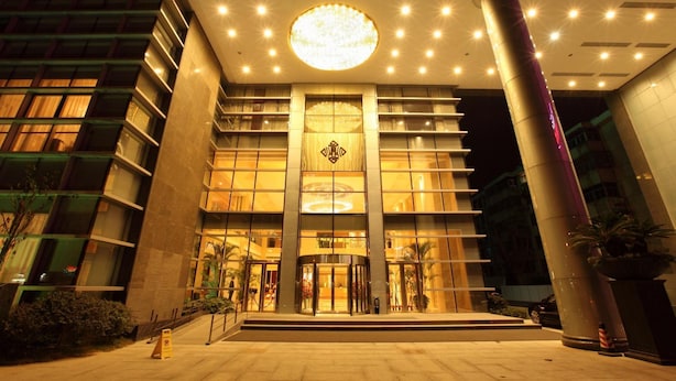 A modern hotel entrance with a circular light fixture above the doors, a central entrance with a double door, and a vertical column on the right. - Nanjing New Century Hotel (Nanjing)